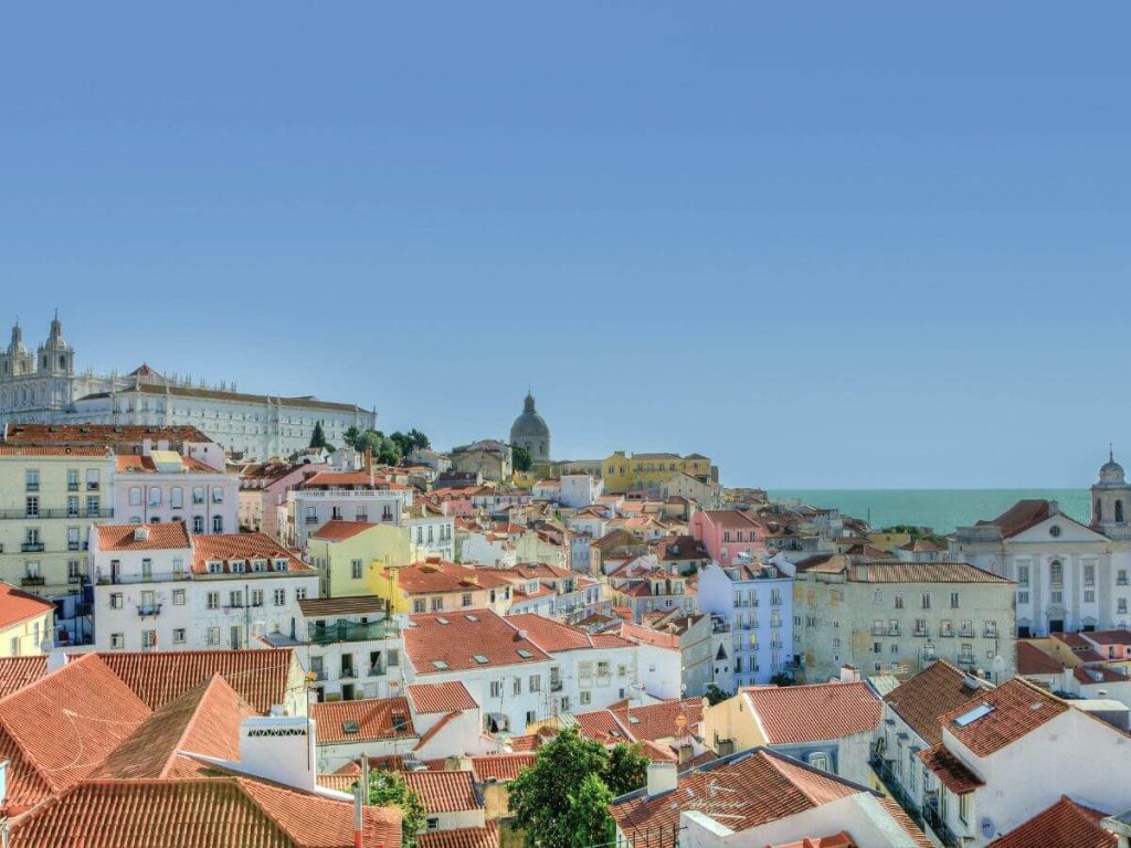 Terracotta rooftops of Lisbon set against a blue sky