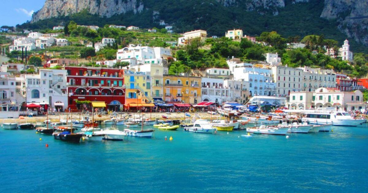 Amalfi coast view from the sea with colourful buildings and boats docked